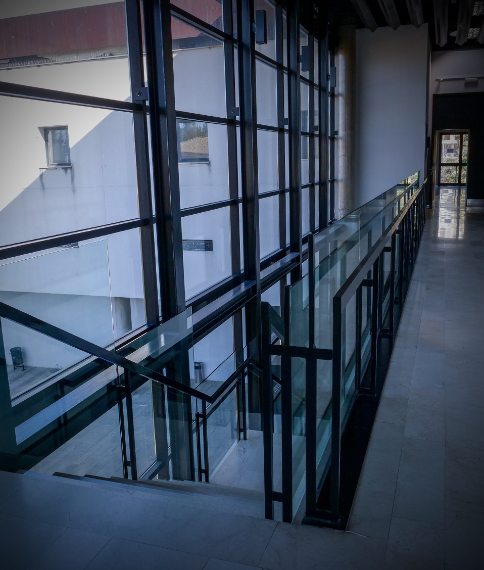 Pasillo de la planta superior de la Facultad de Bellas Artes con las escaleras descendentes a la izquierda